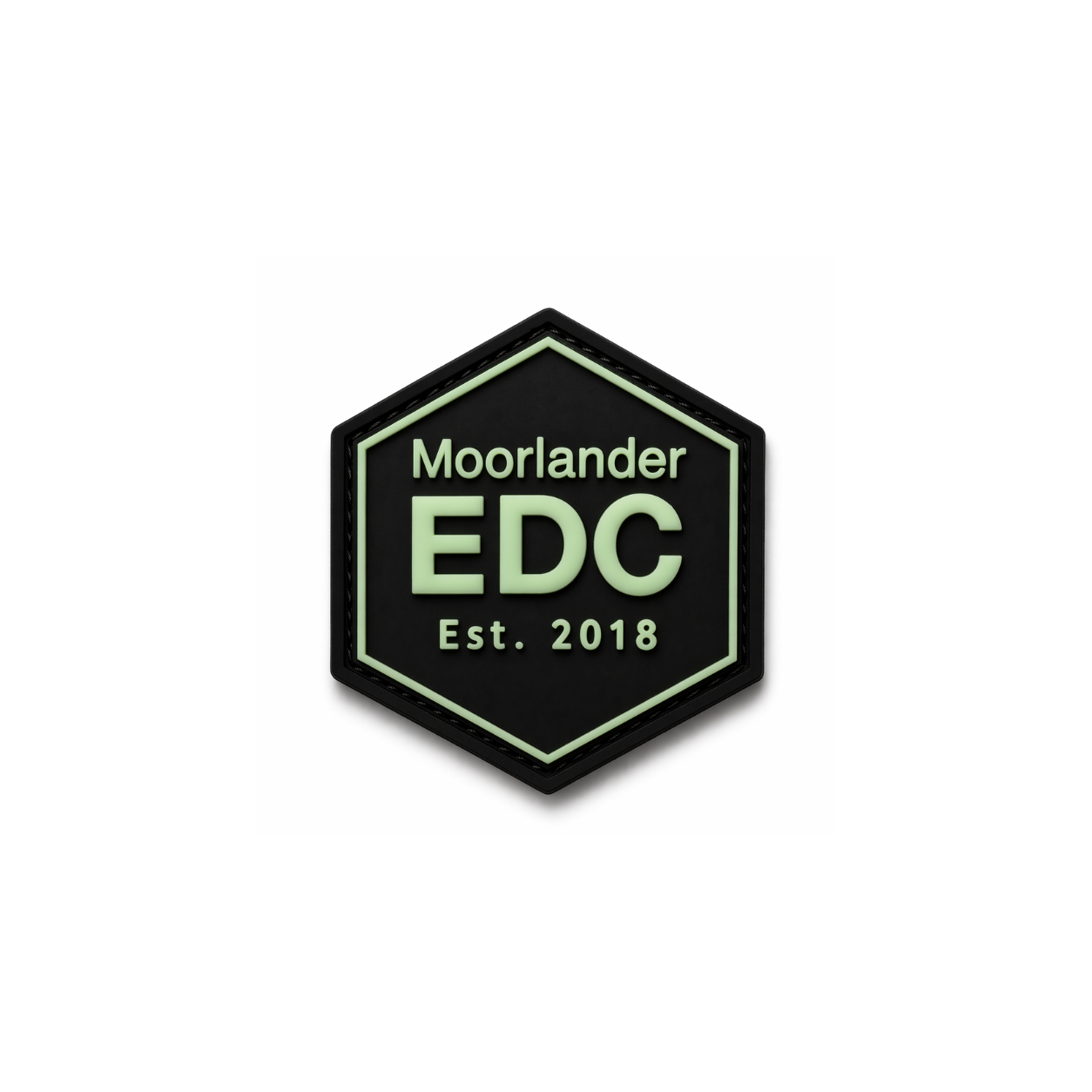 Moorlander x FirmGuards EDC PVC patch with glow in the dark green lettering on black hexagon base, premium morale patch for everyday carry gear